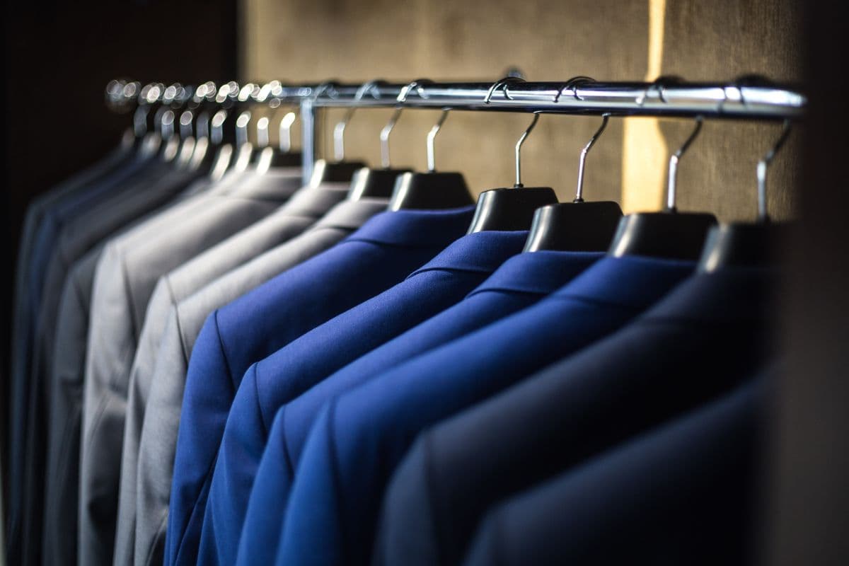 Navy suit fabrics hanging in the workshop